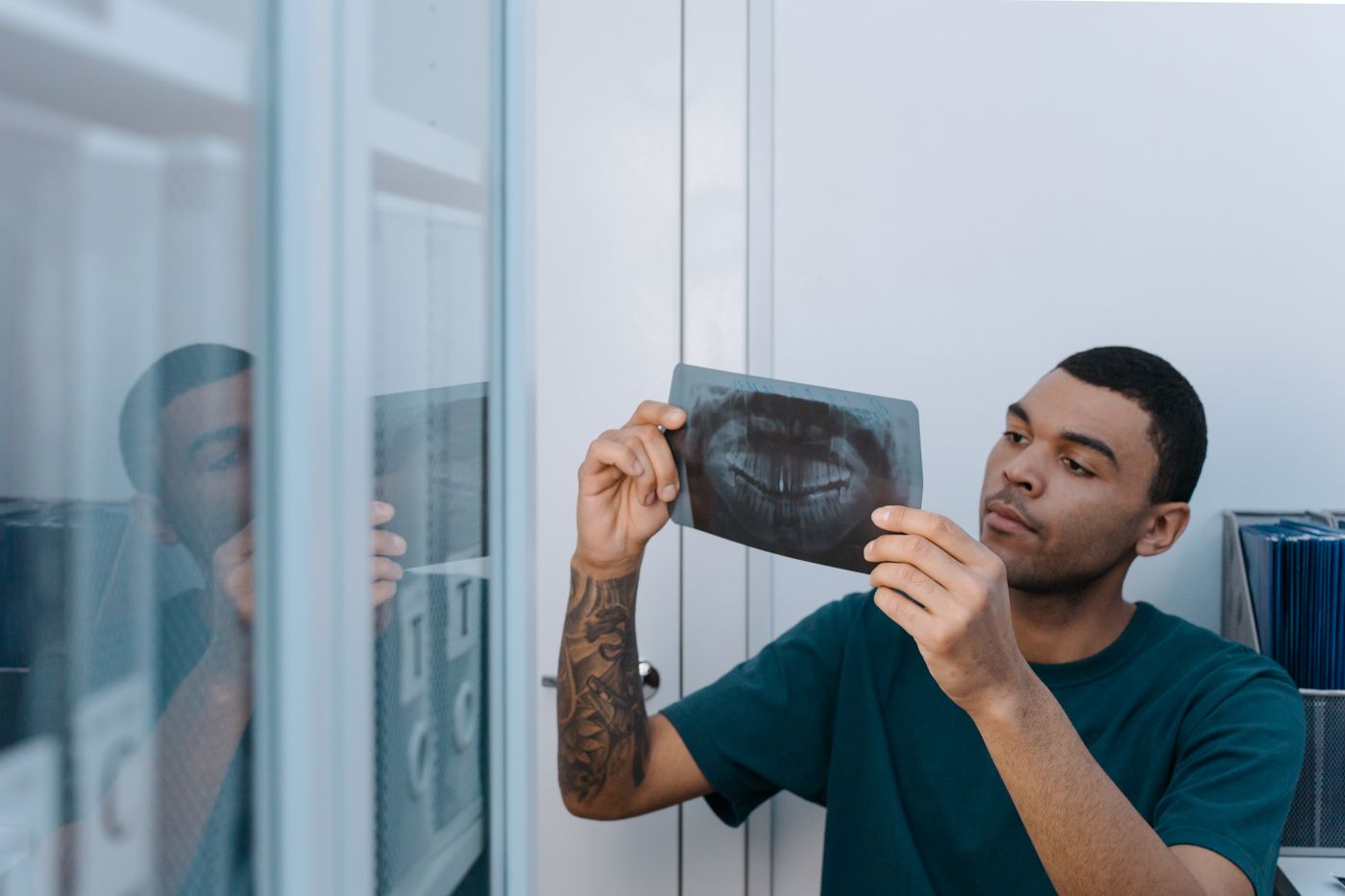A dentist reviewing a dental X-ray to assess whether a tooth can be saved