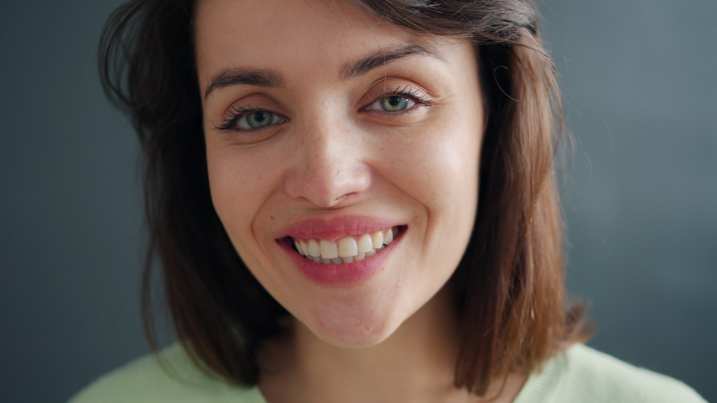 A patient smiling after keeping her natural tooth with root canal treatment